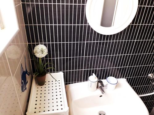 un bagno piastrellato nero con lavandino e specchio di Sadinahome a Setúbal