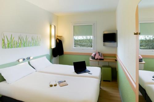 a hotel room with a bed with a laptop on it at Ibis Budget Madrid Getafe in Getafe