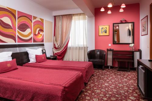 a hotel room with two beds and a mirror at Grand Hotel in Braşov
