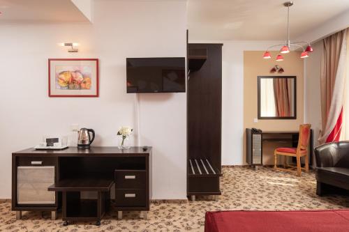 a hotel room with a desk and a living room at Grand Hotel in Braşov