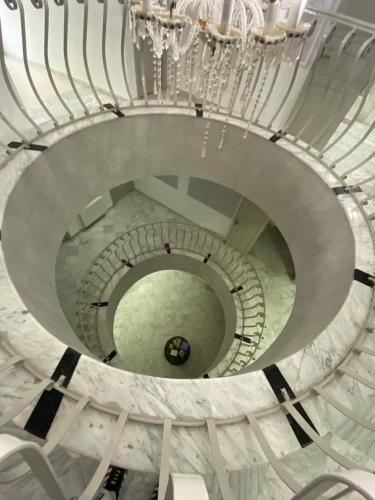 a spiral staircase in a building with a chandelier at Hôtel le calife in Tunis