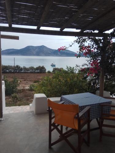 a table and chairs on a patio with a view of the water at Ammos Studio in Koufonisia