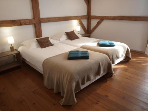 due letti in una stanza con pavimenti in legno di Grand gîte Gastes a Gastes