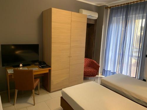a bedroom with a cabinet and a desk with a computer at Flying Hotel in San Maurizio Canavese
