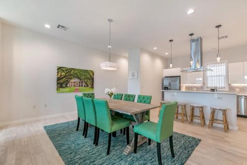 a dining room with a wooden table and green chairs at Private Townhouse in a Secure Location in New Orleans