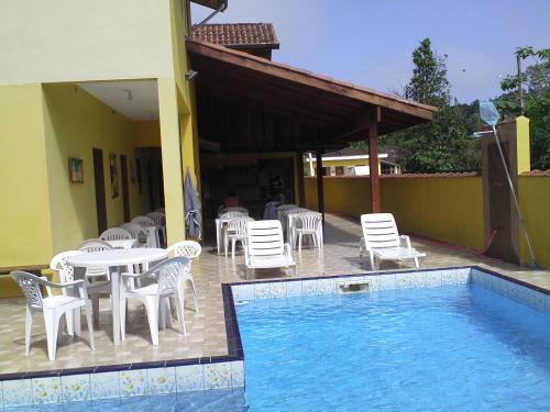 a patio with a table and chairs and a pool at Makitub in Boracéia