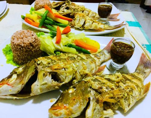 a plate of food with fish and vegetables on a table at Villa 252 Kosgoda in Kosgoda