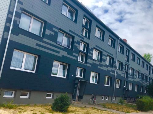 Gerwisch的住宿－Apartment vor Magdeburg，一座蓝色的建筑,前面有一辆自行车停放