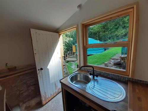 a kitchen with a sink and a large window at Oakdean Cottage Yurt in Blakeney