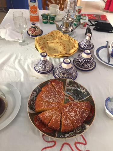 a table with a table cloth with a cake on it at Europa mirlef t aventur Guest House in Mirleft