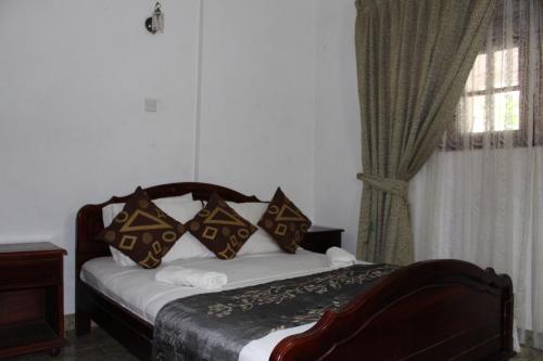 a bedroom with a bed with pillows and a window at Bird's Nest by Natures Bliss in Ragama