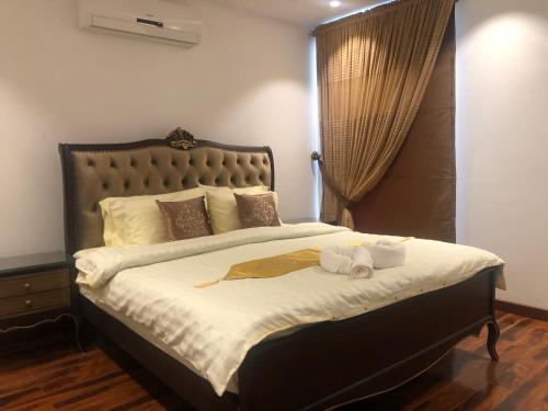 Royal Two Bed Room Luxury Apartment Gulberg في لاهور: غرفة نوم عليها سرير وفوط