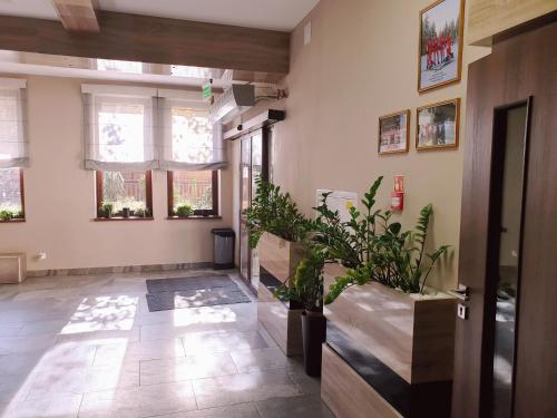 a hallway with plants and windows in a building at Perła Podhala in Szaflary