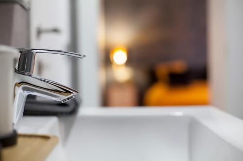 a bathroom sink with a faucet on a counter at Luxury Suites Grotemarkt by Rikas Hotels in Antwerp