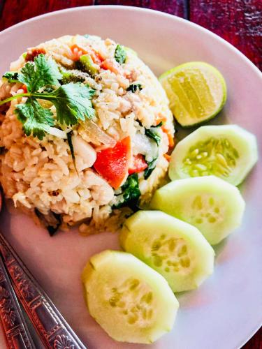 a plate of food with rice and vegetables and pickles at Numpu Baandin in Sam Roi Yot