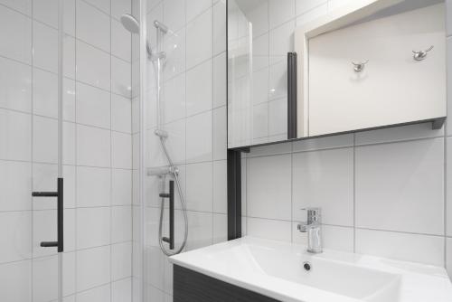uma casa de banho com um lavatório e um chuveiro com um espelho. em De Stal em Kaatsheuvel