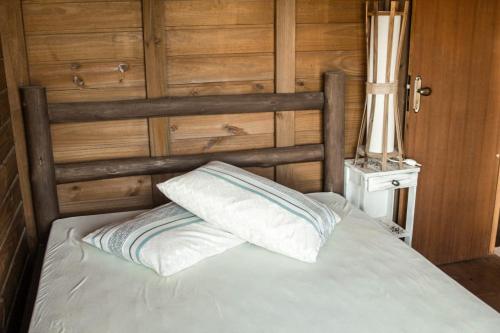 a bed in a room with a wooden wall at Cabanas Mahalo in Imbituba