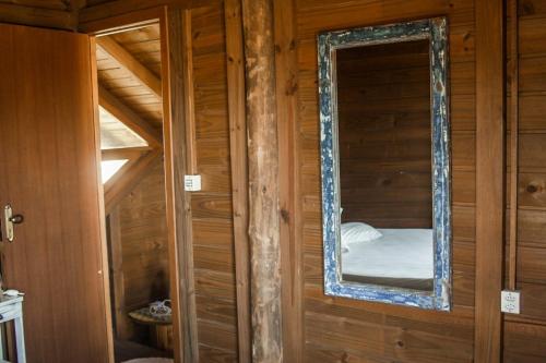 a mirror on a wooden wall in a room at Cabanas Mahalo in Imbituba