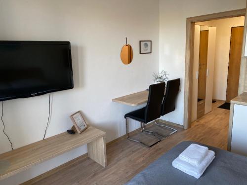 uma sala de estar com uma televisão e uma mesa e cadeiras em Apartment Poprad em Poprad