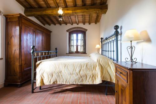 a bedroom with a bed and a table and a window at Agriturismo Bioli in Querceto