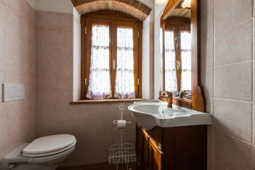 a bathroom with a sink and a toilet and a window at Agriturismo Bioli in Querceto