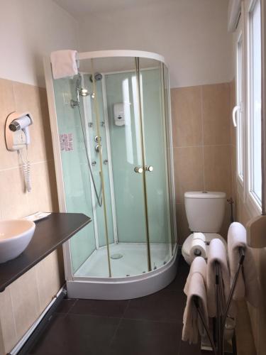 a bathroom with a shower and a toilet and a sink at Hotel Restaurant Cousseau in Parentis-en-Born