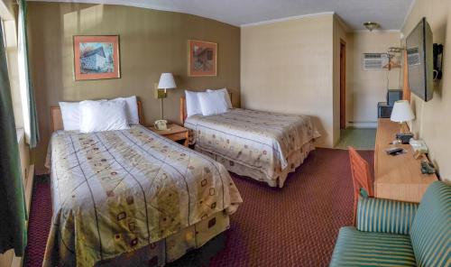 a hotel room with two beds and a chair at Economy Inn in Taylorville