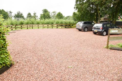 two cars parked in a gravel parking lot at Het Groene Wout in Goudriaan