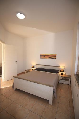 ボーザにあるAppartamenti Villa Elisaのベッドルーム1室(大型ベッド1台、ランプ2つ付)