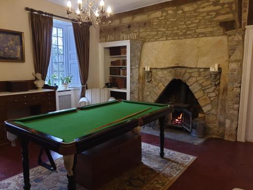 a living room with a pool table and a fireplace at The Loft @ Ford House in Yetminster