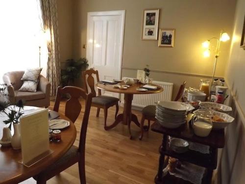 sala de estar con mesa, mesa y sillas en Hazel Bank Bed& Breakfast, en Moffat