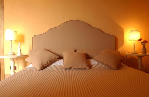 a bedroom with a large bed with two lamps at Relais Poggio al Vento in Pomarance
