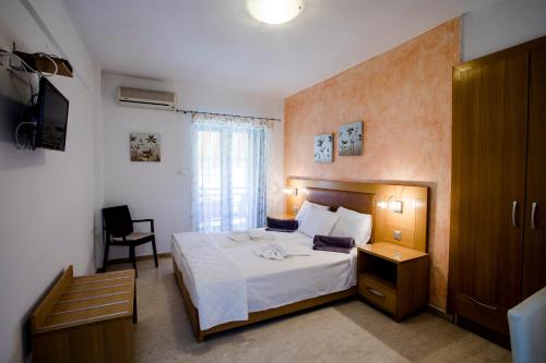 a hotel room with a bed and a television at Maik Apartments in Metamorfosi