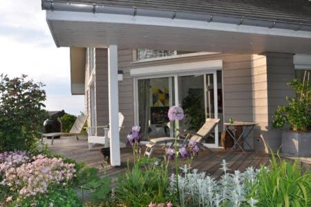 a porch of a house with chairs and flowers at le montanet in Thollon