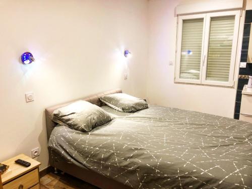 a bedroom with a bed with two pillows and a window at Au lit de Vin in Saint-Sulpice-de-Faleyrens