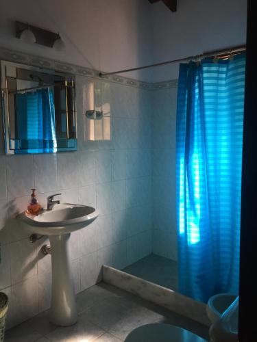 baño con lavabo y cortina de ducha azul en Casa muy cómoda y acogedora, en Punta del Este