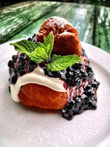 a white plate with a doughnut with mint on it at Pensiunea Apfelhaus in Cisnadioara