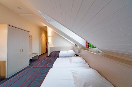Katil atau katil-katil dalam bilik di Hotel Leo Station, Villa et Annexes