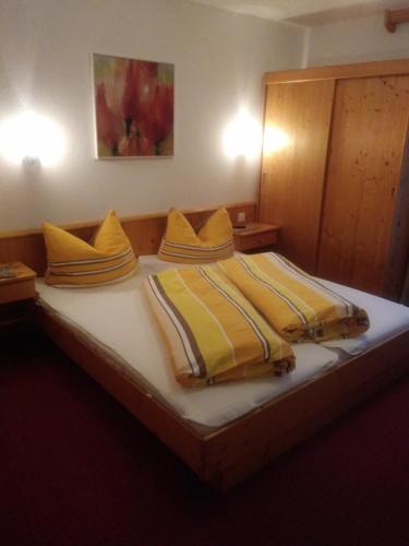 un grande letto con coperte gialle e cuscini sopra di Bella Mira a Samnaun - Laret