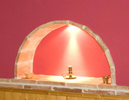 une arche dans un mur avec une lampe sur une table dans l'établissement Torrefolch, à Forcall