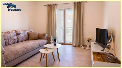 ein Wohnzimmer mit einem Sofa und einem TV in der Unterkunft TayLa-Apartment Vodice in Vodice