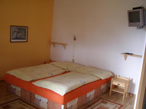 a small bed in a room with a tv on the wall at Privát Liptov 11 in Liptovský Mikuláš
