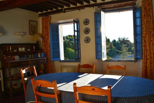une salle à manger avec une table et des chaises et deux fenêtres dans l'établissement Maison Honorine, à Mons