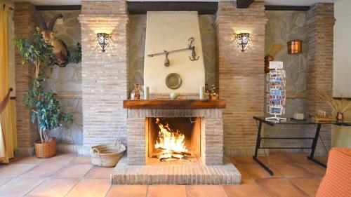 a fire place with a fireplace and a stone wall at La Posada del Conde in Ardales