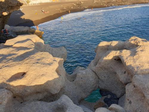 a group of rocks in the water next to a beach at Ajuy Tortuga House in Ajuy