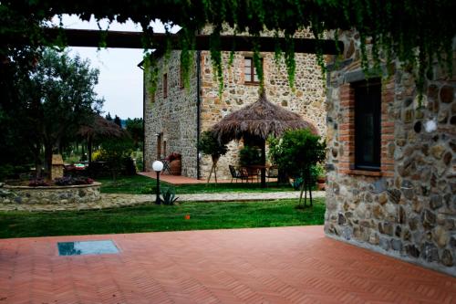 an outside view of a stone building with a patio at Relais Poggio al Vento in Pomarance