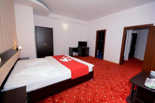 a hotel room with a bed with a red carpet at Hotel Magic - City Center in Piteşti