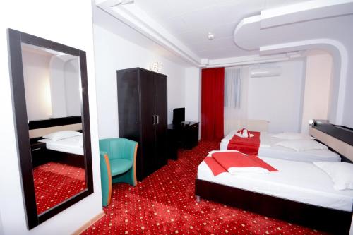 a hotel room with two beds and a mirror at Hotel Magic - City Center in Piteşti