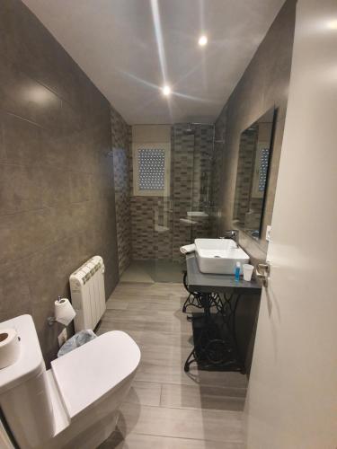 Łazienka z białą toaletą i umywalką w obiekcie Pensió Costa Brava w Sant Antoni de Calonge