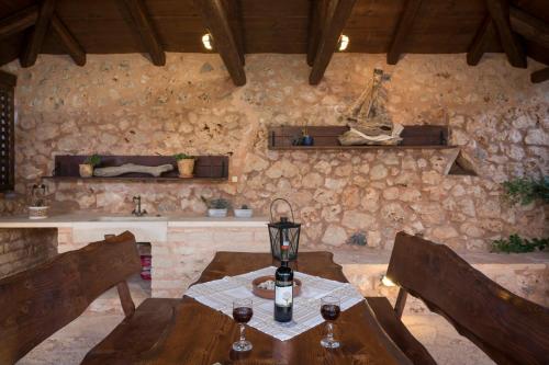 a room with a table and chairs and a stone wall at Xatheri Villas in Vamos